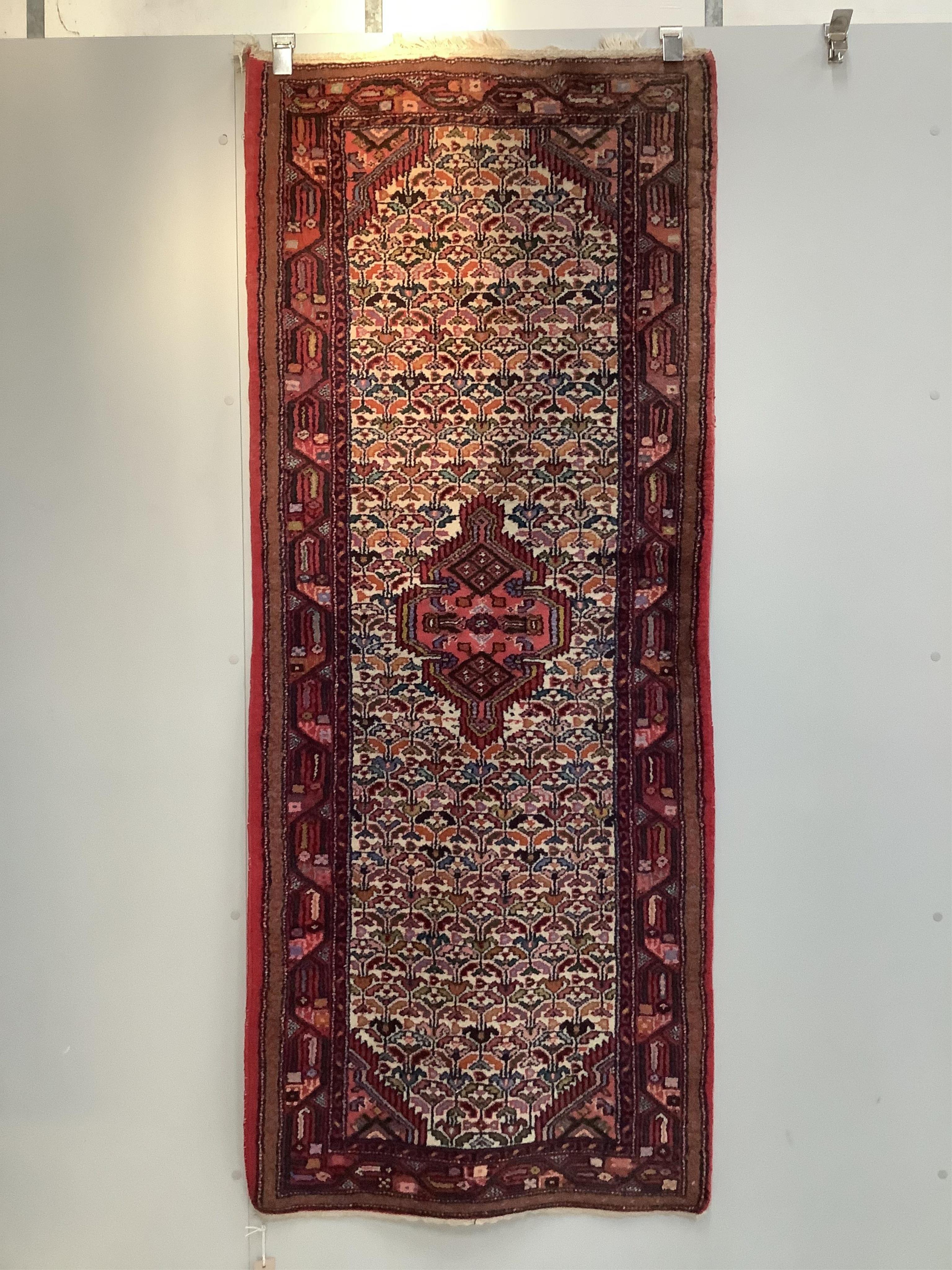 A North West Persian ivory ground rug, 192 x 78cm. Condition - fair